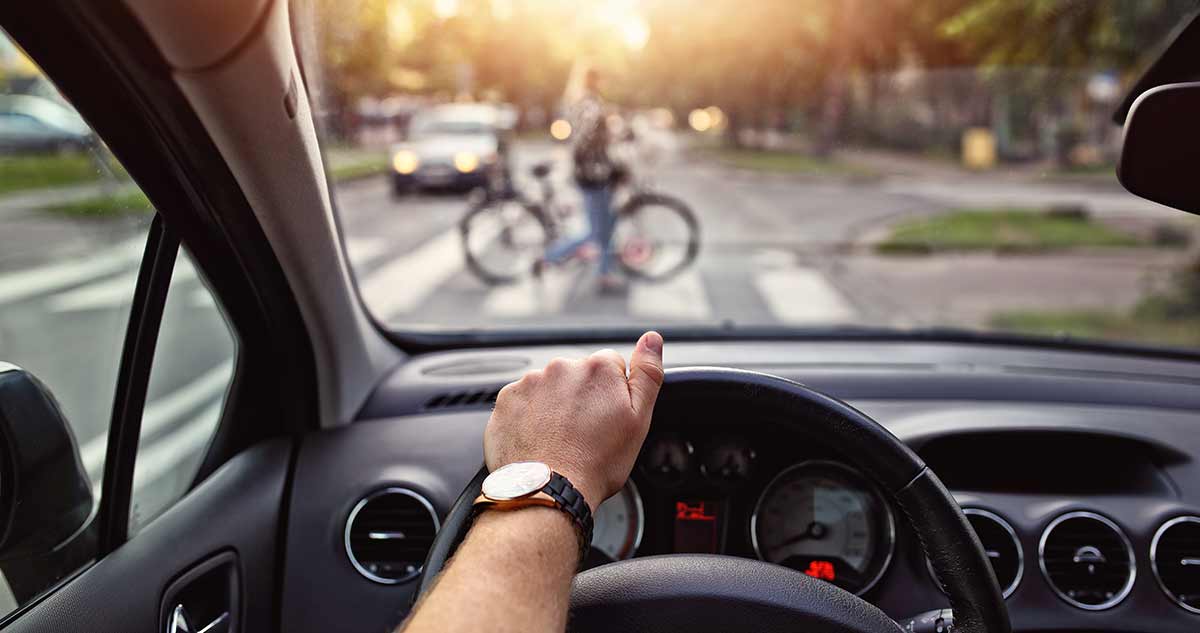 driver watching bike in crosswalk